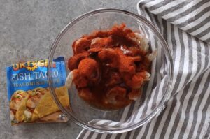 A glass bowl filled with shrimp and spices